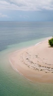 Yeşil bitki örtüsünün sığ turkuaz denizle çevrili olduğu ücra bir kumlu ada. Siargao, Filipinler. Kangkangon Adası.