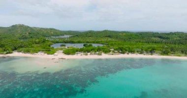 Mercan resifli gök mavisi deniz suyu. Dalgalar kumsala çarpıyor. Santa Fe, Tablas, Romblon. Filipinler.