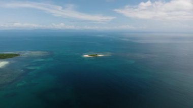 Mavi tropikal denizde tek başına küçük kumlu adanın havadan görünüşü. Siargao, Filipinler.