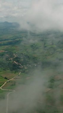 Tarımsal arazisi ve tarlaları sisle kaplı tropik bir dağ. Mindanao, Filipinler. Dikey görünüm.