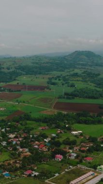 Şehir ve çeltik tarlaları olan dağ manzarası. Mindanao, Filipinler. Dikey görünüm.