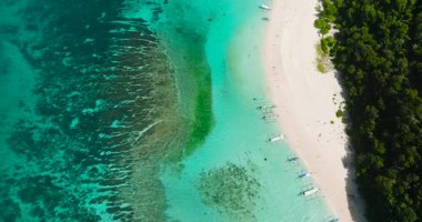 Temiz su ve beyaz kum üzerinde turist botlarıyla kıyı şeridi. Puka Deniz Kabuğu Sahili. Boracay, Filipinler.