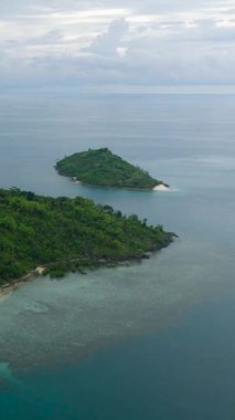 Mavi gökyüzü ve bulutların altında kumlu plajı olan Topical Adası. Zamboanga, Filipinler 'deki Buh-Buh Adası. Dikey görünüm.