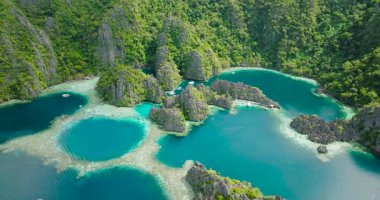 Yeşil Göl ve İkiz Göl. Turist tekneleri ve kireçtaşı kayaları var. Coron, Palawan. Filipinler.