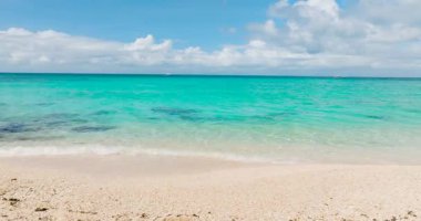 Kumlu sahilde okyanus dalgaları. Mavi gökyüzü ve bulutlar. Puka Deniz Kabuğu Sahili. Boracay, Filipinler.