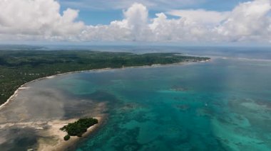 Turkuaz su ve mercan resifi yemyeşil kıyı şeridi yakınlarında. Hanoyoy Adası, Siargao, Filipinler.