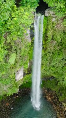 Camiguin Adası 'ndaki Katibawasan Şelalesinin insansız hava aracı görüntüsü. Filipinler. Seyahat konsepti. Dikey video.