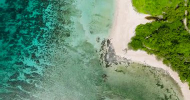 Turkuaz suyun üzerine güneş ışığı yansıması. Tropik sahildeki mercan kayalıkları. Santa Fe, Tablas, Romblon. Filipinler. 5 bin..