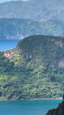 Mavi denizi aşan tekneler. Tropik adalarda kireçtaşı kayaları. El Nido, Palawan. Filipinler. Dikey görünüm.