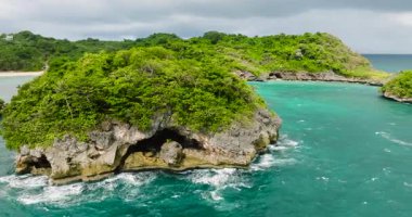 Gök mavisi sular ve okyanus dalgalarıyla çevrili küçük bir ada. Boracay, Filipinler.