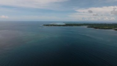 Denizin geniş bir manzarası ve uzaktan görülebilen bir ada. Siargao, Filipinler.