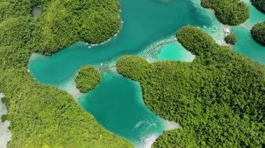 Açık turkuaz lagünün havadan görünüşü yakınlarda demirli tekneleri olan yeşil orman adaları tarafından çevrelenmiştir. Sugba Mavi Göl, Siargao, Filipinler.