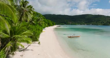 Tiamban Sahili 'nde şeffaf deniz suyunda yüzen tekneler. Mavi gökyüzü ve bulutlar. Romblon, Filipinler.