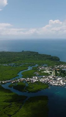 Açık mavi denize giden suyolu olan mangrovlarla çevrili küçük bir sahil kasabası. Siargao, Filipinler.