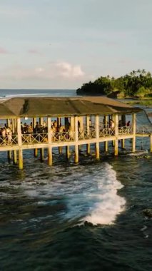 Kalabalık ahşap iskele köşkü denize doğru uzanıyor. Siargao, Filipinler. Bulut 9 Sörf Alanı.