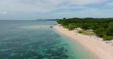 Mercanlı şeffaf turkuaz deniz suyu. Santa Fe, Tablas, Romblon 'daki beyaz kumsalda dalgalar. Filipinler.