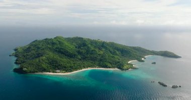 Beyaz kumlu plajlar ve güneş yansımalı mavi deniz. Cobrador Adası. Romblon, Filipinler.