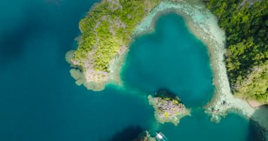 Coron, Palawan 'da turkuaz gölün üzerinden geçen bir tekne. Filipinler.