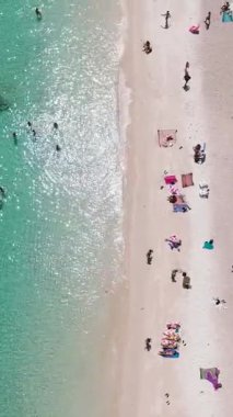 Rahatlatıcı turistlerle dolu parlak kumlu plaj, berrak turkuaz sular ve berrak bir gökyüzünün altında güneşli kum. Ao Leuk, Koh Tao, Tayland.