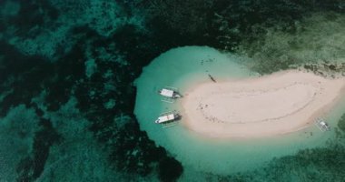 Turkuaz sığ deniz suyunda bir kumluk ada tarafından demirlenmiş tekneler. Çıplak Ada. Siargao, Filipinler.