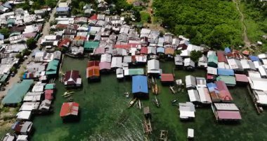 Sığ turkuaz denizin üzerinde yüzen tekneli geleneksel stilt evler. Siargao, Filipinler.