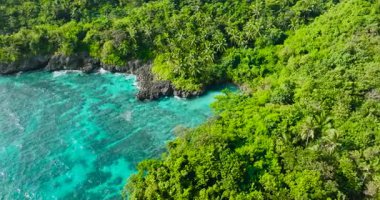 Turkuaz deniz suyu ve kaya dalgalarıyla kıyı şeridi. Carabao Adası. San Jose, Romblon. Filipinler.
