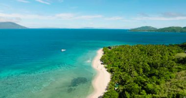 Temiz deniz suyuyla beyaz sahilin insansız hava aracı görüntüsü. Mavi gökyüzü ve bulutlar. Logbon Adası. Romblon, Filipinler.