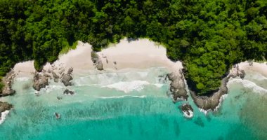 Beyaz sahilde güzel dalgalar. Sahilde kayalar ve beyaz kumlar. El Nido, Palawan. Filipinler.