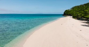 Dalgalar ve şeffaf suyla beyaz sahilin havadan görünüşü. Cobrador Adası. Romblon, Filipinler.