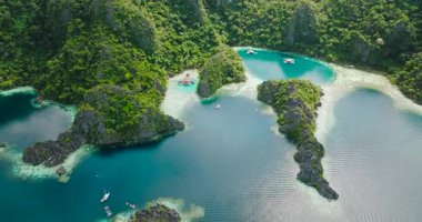 Laknisan Gölünde ve İkiz Göl 'de tekneli turkuaz su manzarası. Coron, Palawan. Filipinler.