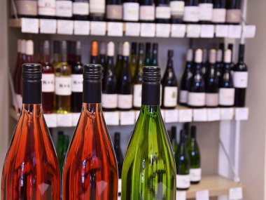 Şarap dükkanında şarap şişeleri ve eve teslim için hazır. Şarap dükkanındaki ahşap rafta şarap şişeleri