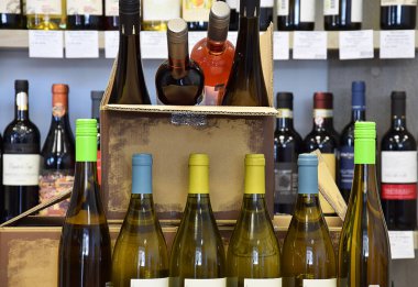 Şarap dükkanında şarap şişeleri. Şarap bir kutuya konur ve eve teslim edilir.