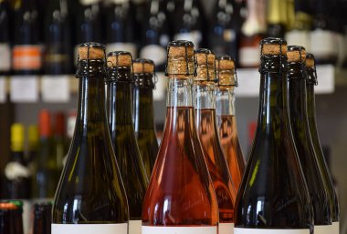 Şarap dükkanında hafif köpüklü şarap şişeleri ve eve teslim için hazır.