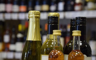 Şarap dükkanında farklı boyutlarda şarap şişeleri var ve eve servis için hazır.