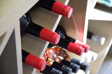 Şarap dükkanındaki ahşap rafta şarap şişeleri