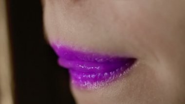 Fashion model lips. Purple lipstick on girl lips. Sexy female mouth closeup