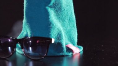 Winter fashion. Knitted hat and sunglasses. Blue woolen knitted cap