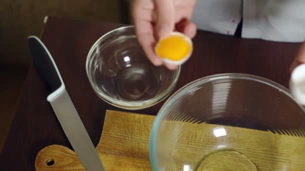 Huevo cayendo en un tazón de vidrio. Preparación de ingredientes para hornear pastel. Cocinar alimentos — Vídeos de Stock