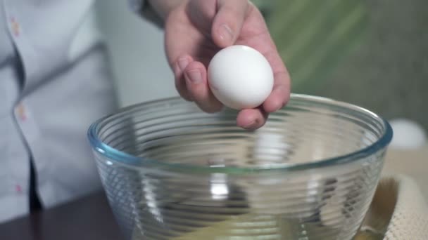 准备食物。打破鸡蛋。烘焙配料。鸡蛋掉进玻璃碗 — 图库视频影像