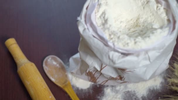 Ingredienser för Baring bröd. Mjöl väska, vete, brödkavel och träsked — Stockvideo