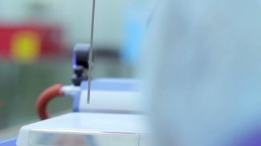 Sütün analizi. Bilim adamı laboratuvar ekipmanları üzerine süt ile ölçüm fincan koymak