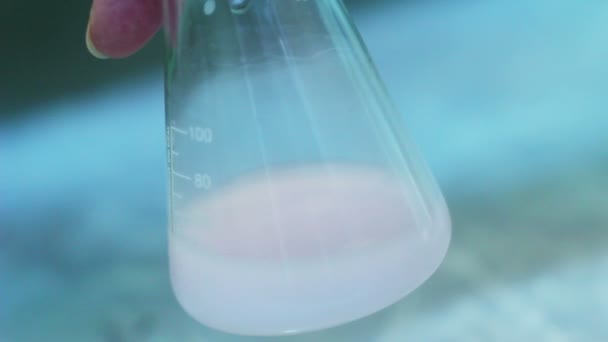 Reacción química en frasco. Sacudiendo el líquido en el frasco. Investigación de laboratorio — Vídeo de stock