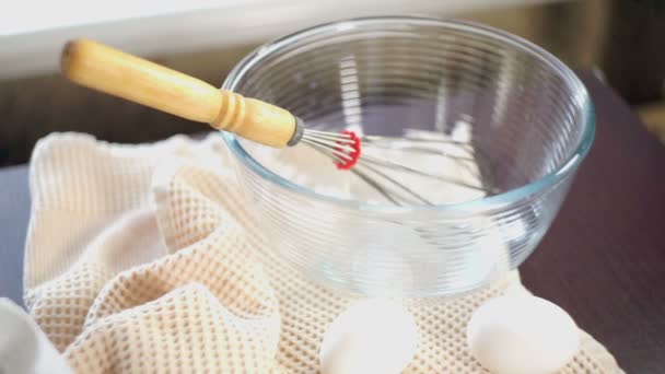 Food cooking equipment. Whisk in glas bowl. Closeup. Ingredients for cake baking — Stock Video