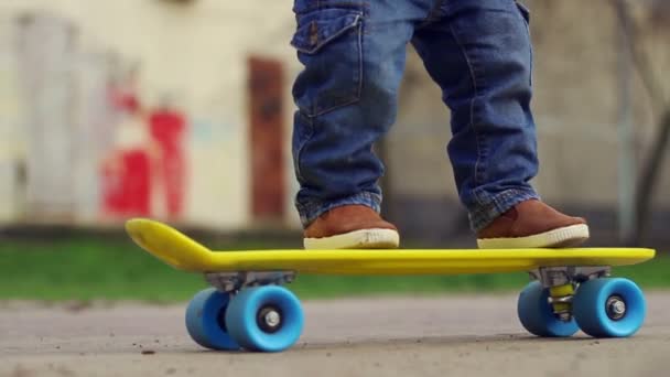 Bambino sullo skateboard. Bambino gambe cavalcare su skate in outdoor — Video Stock