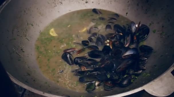 Matlagning musslor på pannan. Musslan beskjuter kokas i kastrull på gatan matfestival — Stockvideo