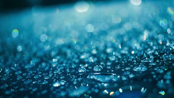 L'eau tombe sur le verre après la pluie. Gouttelettes d'eau sur verre de couleur bleue 