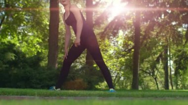 Kadın keyfi yerinde eğitim. Kadının yapması ileri doğru yatırır. Güneş patlaması Park