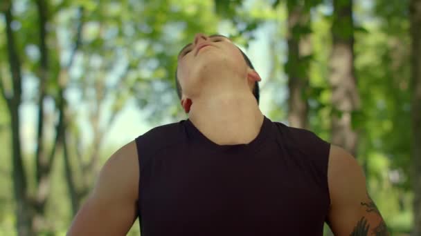 Fitness uomo riscaldare il collo all'aperto. Primo piano di uomo in forma che si estende nel parco — Video Stock