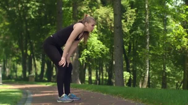 Mulher fitness descansando depois de correr maratona. Menina cansada após o treino ao ar livre — Vídeo de Stock