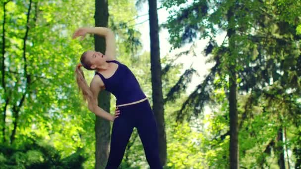 Sportieve vrouw doen fitness oefeningen buiten. Vrouwelijke atleet, die zich uitstrekt — Stockvideo